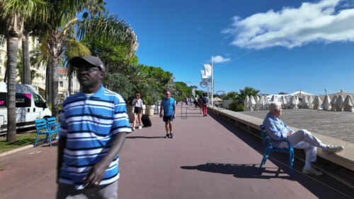 Cannes, France – July 12, 2025: People walking along the seafront on a sunny day - Starpik Stock