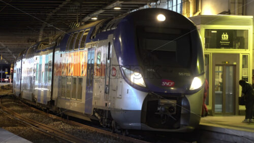 Cannes, France – July 2, 2025: Busy railway station platform with a crowd of passengers waiting as train approaches under the station canopy - Starpik Stock