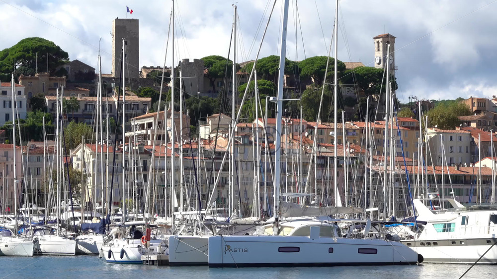 Cannes, France – July 2, 2025: Distant view from the Old Port of a Cannes sign written on a mountain near the Notre Dame d’Esperance church and the Museum of World Explorations - Starpik Stock