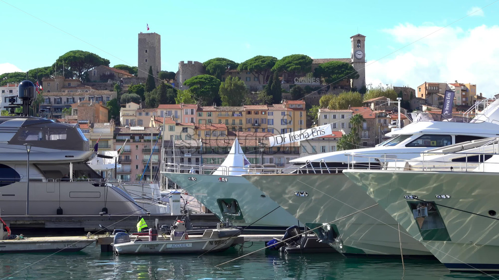 Cannes, France – July 2, 2025: Distant view from the Old Port of a Cannes sign written on a mountain near the Notre Dame d’Esperance church and the Museum of World Explorations - Starpik Stock