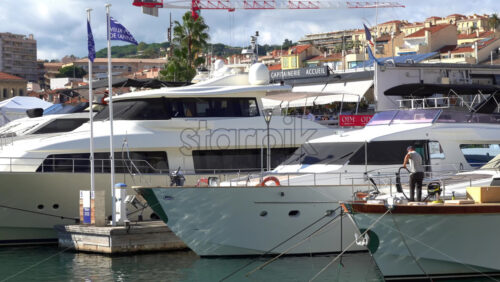 Cannes, France – July 2, 2025: Multiple white boats docked in the Old Port of Cannes in daylight - Starpik Stock