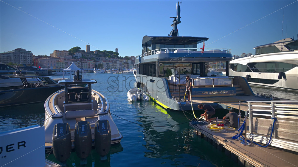 Cannes, France – June 22, 2025: Crew members maintaining the yacht, handling ropes and equipment on the dock and deck - Starpik Stock