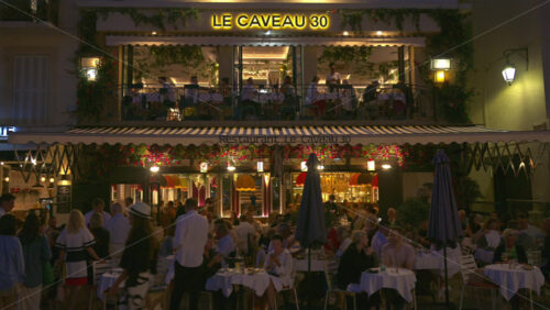 Cannes, France – June 22, 2025: People dining, chatting, and enjoying the warm ambiance in the evening at the Le Caveau 30 restaurant - Starpik Stock