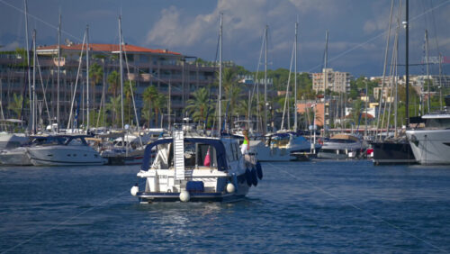 Cannes, France – June 22, 2025: People in a boat moving through the Cannes harbour in daylight - Starpik Stock