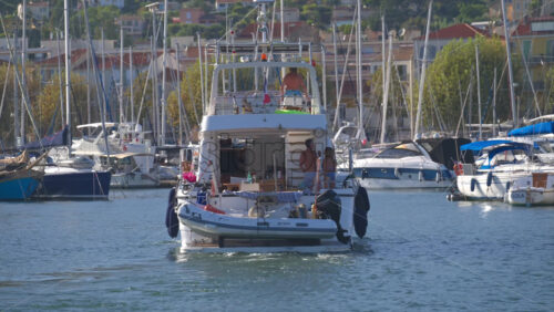 Cannes, France – June 22, 2025: People in a boat moving through the Cannes harbour in daylight - Starpik Stock