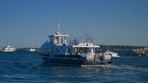 Cannes, France – June 22, 2025: People in a boat moving through the Cannes harbour in daylight - Starpik Stock