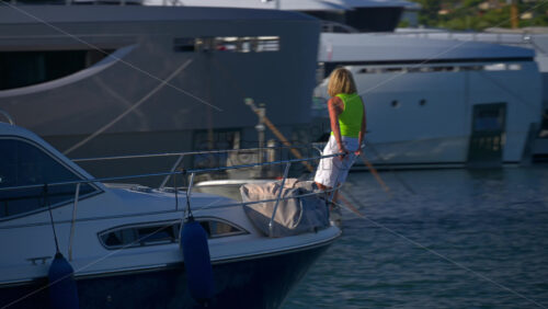 Cannes, France – June 22, 2025: Woman in a boat moving through the Cannes harbour in daylight - Starpik Stock