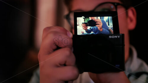 Chisinau, Moldova – August 22, 2025: Child using a Sony digital camera, with the camera screen showing a reflection of a photographer - Starpik Stock