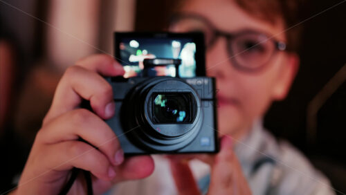 Chisinau, Moldova – August 22, 2025: Child using a digital camera, with the camera screen showing a reflection - Starpik Stock