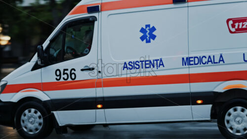 Chisinau, Moldova – June 11, 2025: Ambulance rushing on the streets of the city center on a rainy day - Starpik Stock