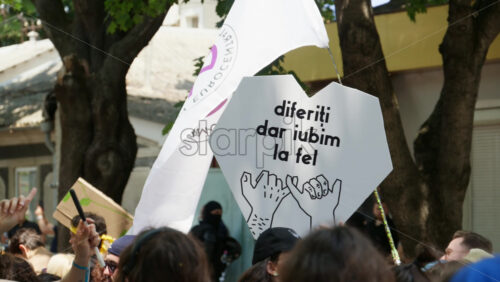 Chisinau, Moldova – June 15, 2025: People marching and holding signs at the Pride Parade in the city center – Translation: “Different but we love the same” - Starpik Stock