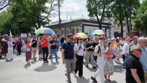 Chisinau, Moldova – June 15, 2025: People marching and holding signs at the Pride Parade in the city center – Translation: “I am telling you straight in your face that love has no gender” - Starpik Stock