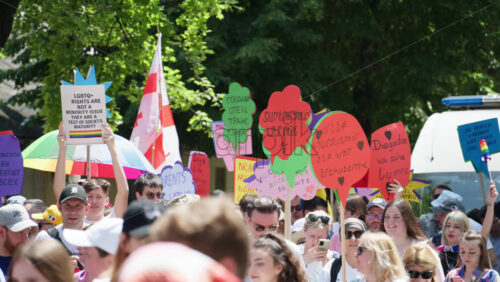 Chisinau, Moldova – June 15, 2025: People marching and holding signs at the Pride Parade in the city center – Translation: “Love will save the world, Proud father of a trans son” - Starpik Stock