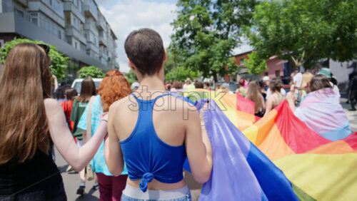 Chisinau, Moldova – June 15, 2025: People marching, holding a big rainbow flag at the Pride Parade in the city center - Starpik Stock