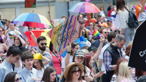 Chisinau, Moldova – June 15, 2025: People marching, holding signs and rainbow flags at the Pride Parade in the city center - Starpik Stock