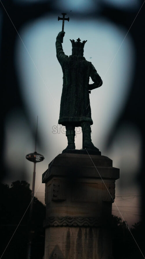 Chisinau, Moldova – June 15, 2025: Stephen the Great statue seen through the out-of-focus curves of a wrought-iron fence. Vertical - Starpik Stock