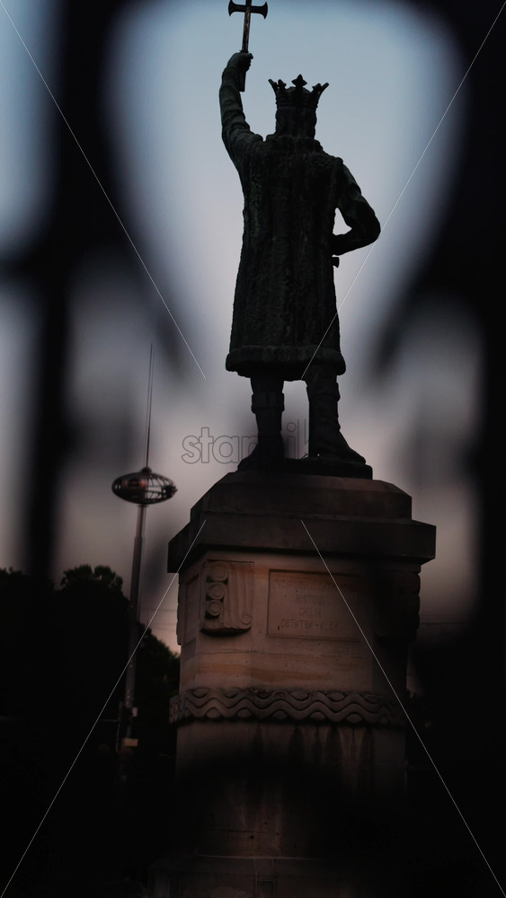 Chisinau, Moldova – June 15, 2025: Stephen the Great statue seen through the out-of-focus curves of a wrought-iron fence. Vertical - Starpik Stock
