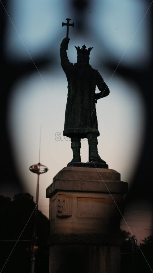 Chisinau, Moldova – June 15, 2025: Stephen the Great statue seen through the out-of-focus curves of a wrought-iron fence. Vertical - Starpik Stock