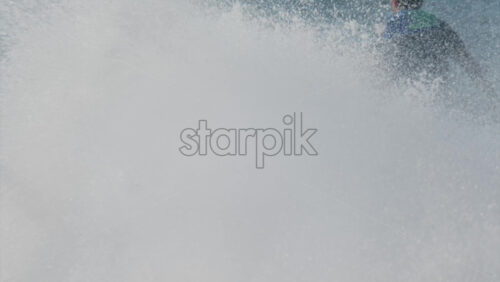 Chisinau, Moldova – June 17, 2025: A man in a black life vest riding a black jet ski at high speed across a calm body of water - Starpik Stock