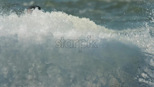 Chisinau, Moldova – June 17, 2025: A man in a black life vest riding a black jet ski at high speed across a calm body of water - Starpik Stock