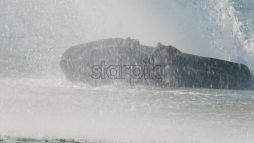 Chisinau, Moldova – June 17, 2025: A man in a black life vest riding a black jet ski at high speed across a calm body of water - Starpik Stock