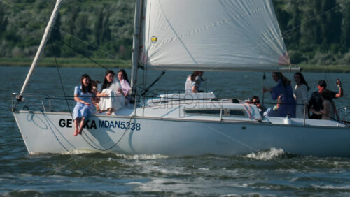 Chisinau, Moldova – June 17, 2025: A man riding a black jet ski at high speed, splashing girls on sailing trip across a calm body of water - Starpik Stock