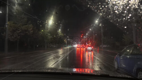 Chisinau, Moldova – June 7, 2025: View from the windshield of a moving car on the streets of the city on a rainy evening - Starpik Stock
