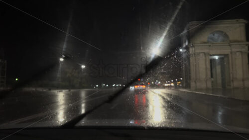 Chisinau, Moldova – June 7, 2025: View from the windshield of a moving car on the streets of the city on a rainy evening - Starpik Stock