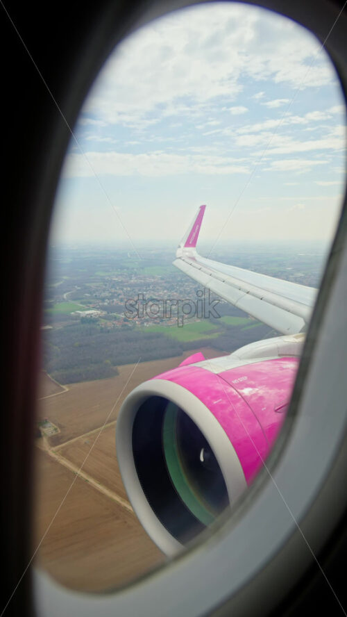 Chisinau, Moldova – March 20, 2025: View of the turbine and wing of a WizzAir airplane from the window. Vertical - Starpik Stock