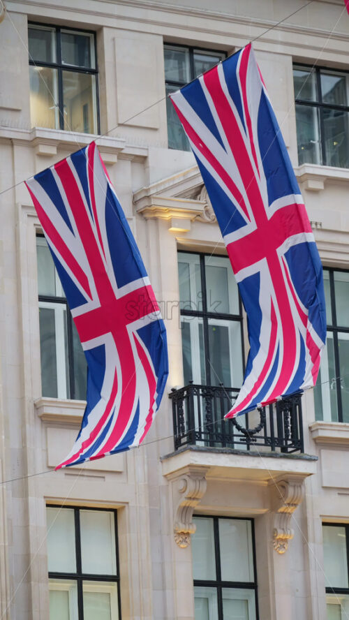 Classic London architecture adorned with waving Union Jack flags. Vertical - Starpik Stock