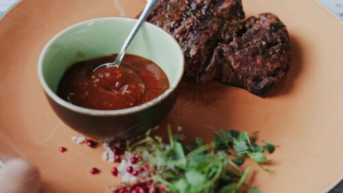 Close up of a Sirloin Steak with Barbecue Sauce and micro-plants on the side - Starpik Stock