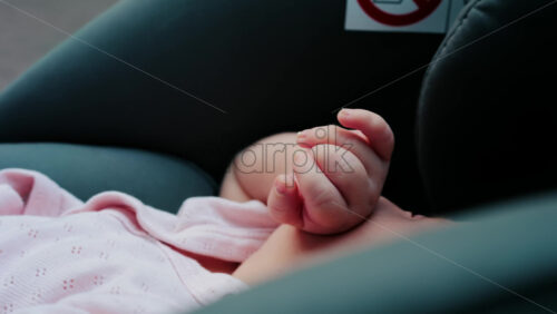 Close up of a baby tiny hands while sitting in a stroller - Starpik Stock