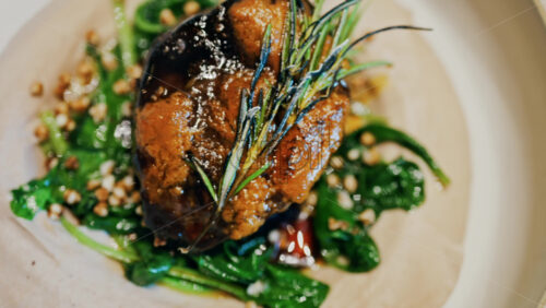 Close up of a beautifully plated beef filet, topped with a golden crust and garnished with rosemary - Starpik Stock
