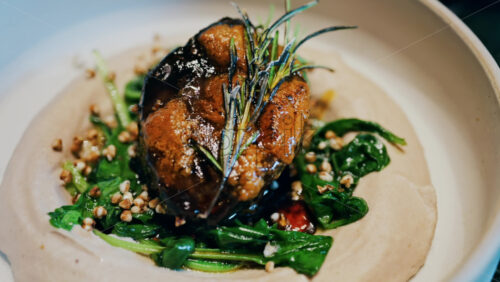 Close up of a beautifully plated beef filet, topped with a golden crust and garnished with rosemary - Starpik Stock