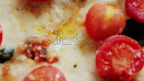 Close up of a classic margherita pizza with cherry tomatoes and basil - Starpik Stock