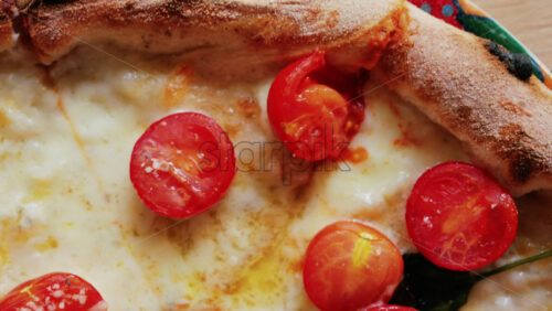 Close up of a classic margherita pizza with cherry tomatoes and basil - Starpik Stock
