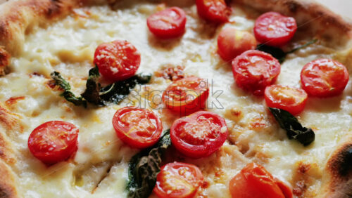 Close up of a classic margherita pizza with cherry tomatoes and basil - Starpik Stock
