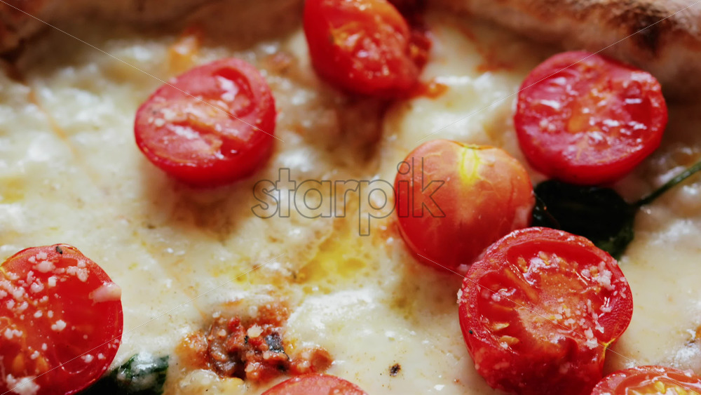 Close up of a classic margherita pizza with cherry tomatoes and basil - Starpik Stock