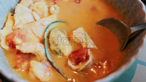 Close up of a creamy seafood stew with mussels, squid, and shrimp - Starpik Stock