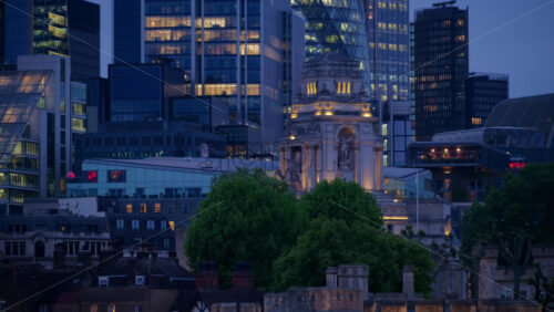 Close-up of a detailed building spire with gothic architectural features illuminated at night in London, England - Starpik Stock