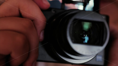Close up of a digital camera lens held by a child, showing reflections in the glass - Starpik Stock