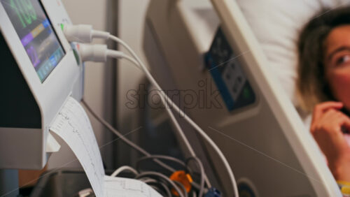 Close-up of a fetal monitor in a doctor’s office, displaying fetal heart rate and uterine contraction data during a prenatal check-up - Starpik Stock