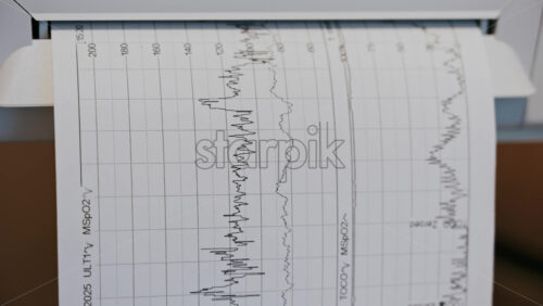 Close-up of a fetal monitor in a doctor’s office, displaying fetal heart rate and uterine contraction data during a prenatal check-up - Starpik Stock