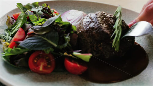 Close up of a filet mignon with a red wine sauce and a fresh salad garnish - Starpik Stock