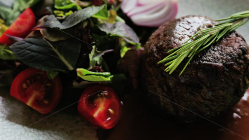 Close up of a filet mignon with a red wine sauce and a fresh salad garnish - Starpik Stock