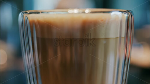 Close up of a glass cup with a latte at a cafe - Starpik Stock