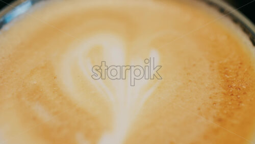 Close up of a glass cup with a latte at a cafe - Starpik Stock