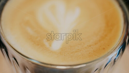 Close up of a glass cup with a latte at a cafe - Starpik Stock