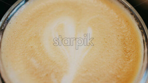 Close up of a glass cup with a latte at a cafe - Starpik Stock