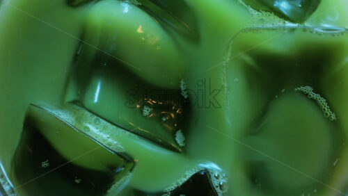 Close up of a glass of an iced matcha on a table at a cafe - Starpik Stock